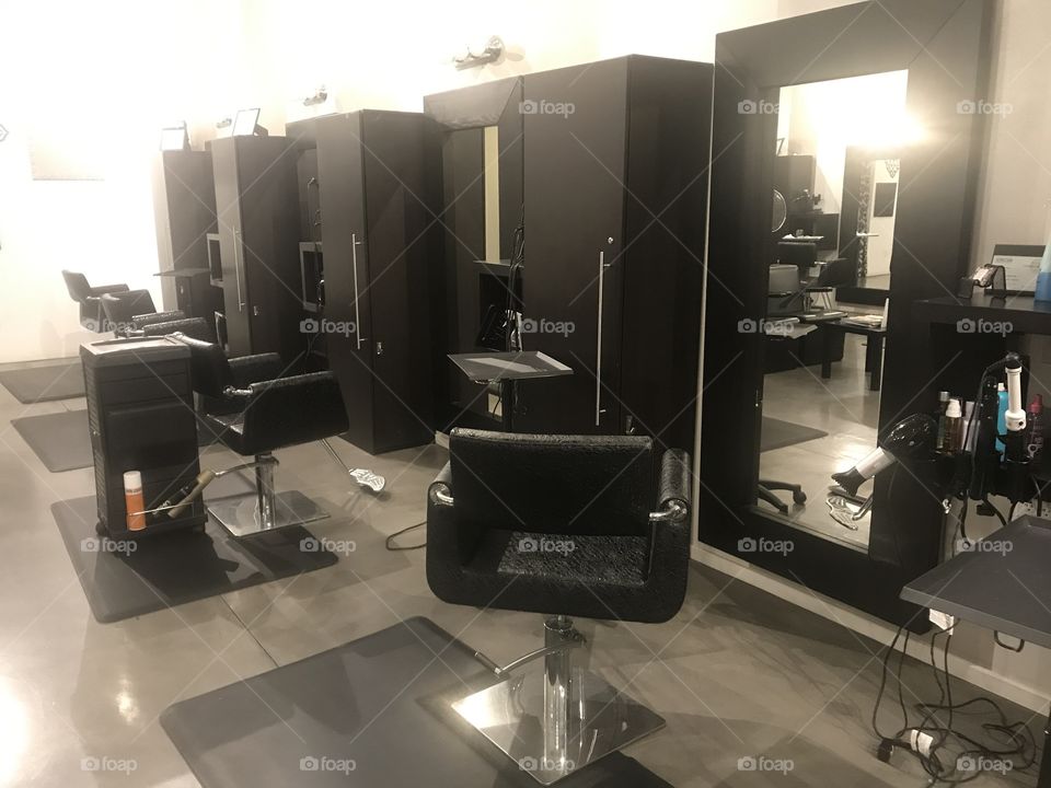An empty salon with no people or product placement. Clean and well illuminated.  Black and white color scheme with a modern look.