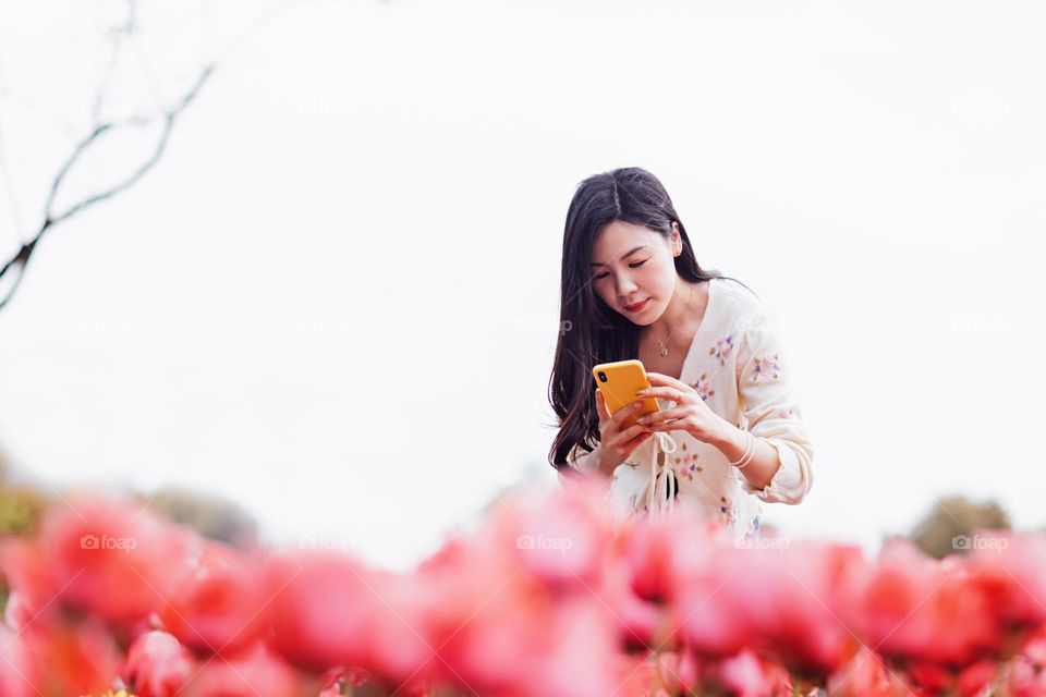 Beautiful Asian woman snapping photo at spring 