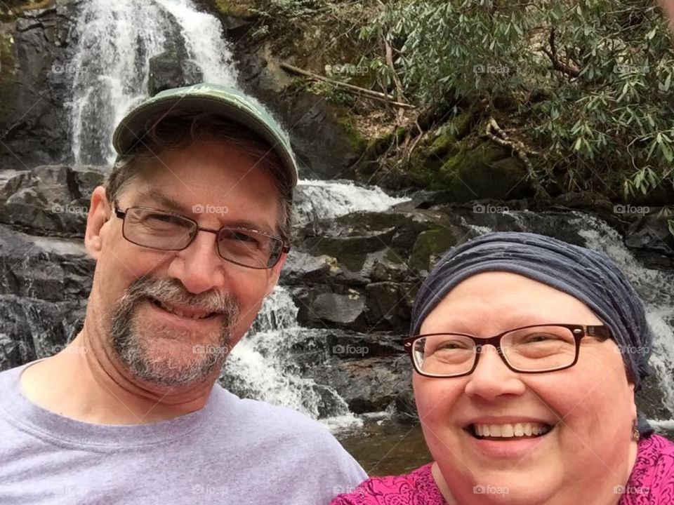 Couple celebrating wife's remission of cancer , hiking in the mountains of Tennessee to a waterfall.