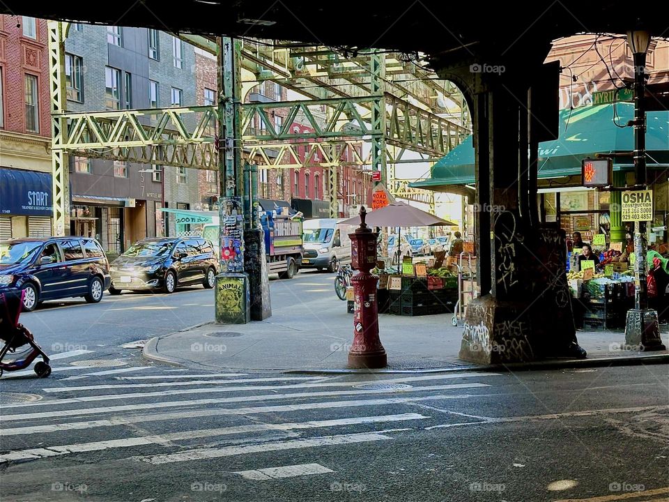 This is the MTA “M” train overpass at the “Myrtle Avenue” station at the intersection with “Broadway” and “Jefferson St” in “Bushwick”, Brooklyn. At the corner is “Mr Kiwi”, a 24 hr Korean deli that serves the neighborhood. 2024. Hypnotic Productions
