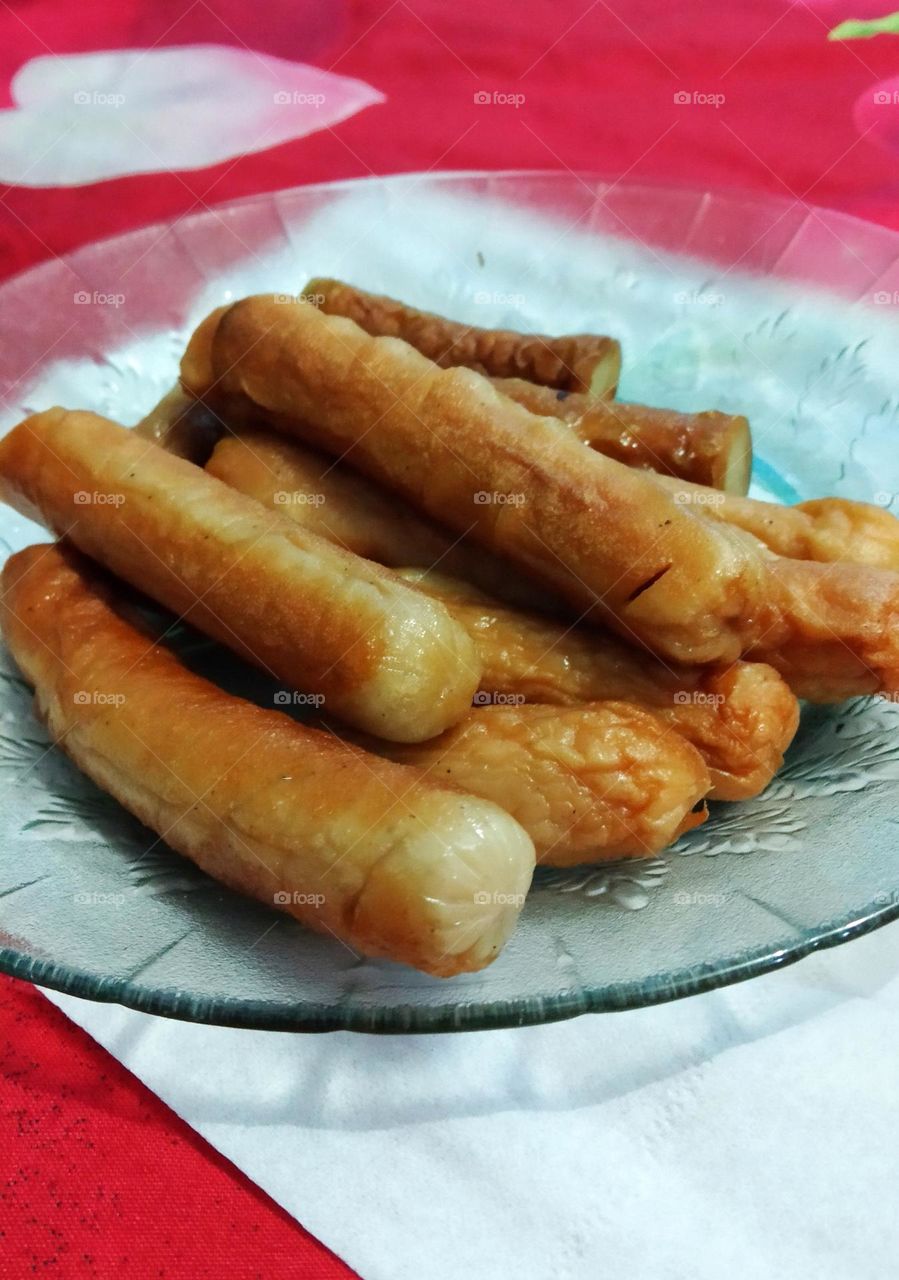Some fried sausage on a clear plate