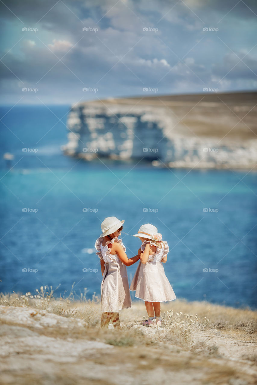 Little sisters in a high rocky seacoast 