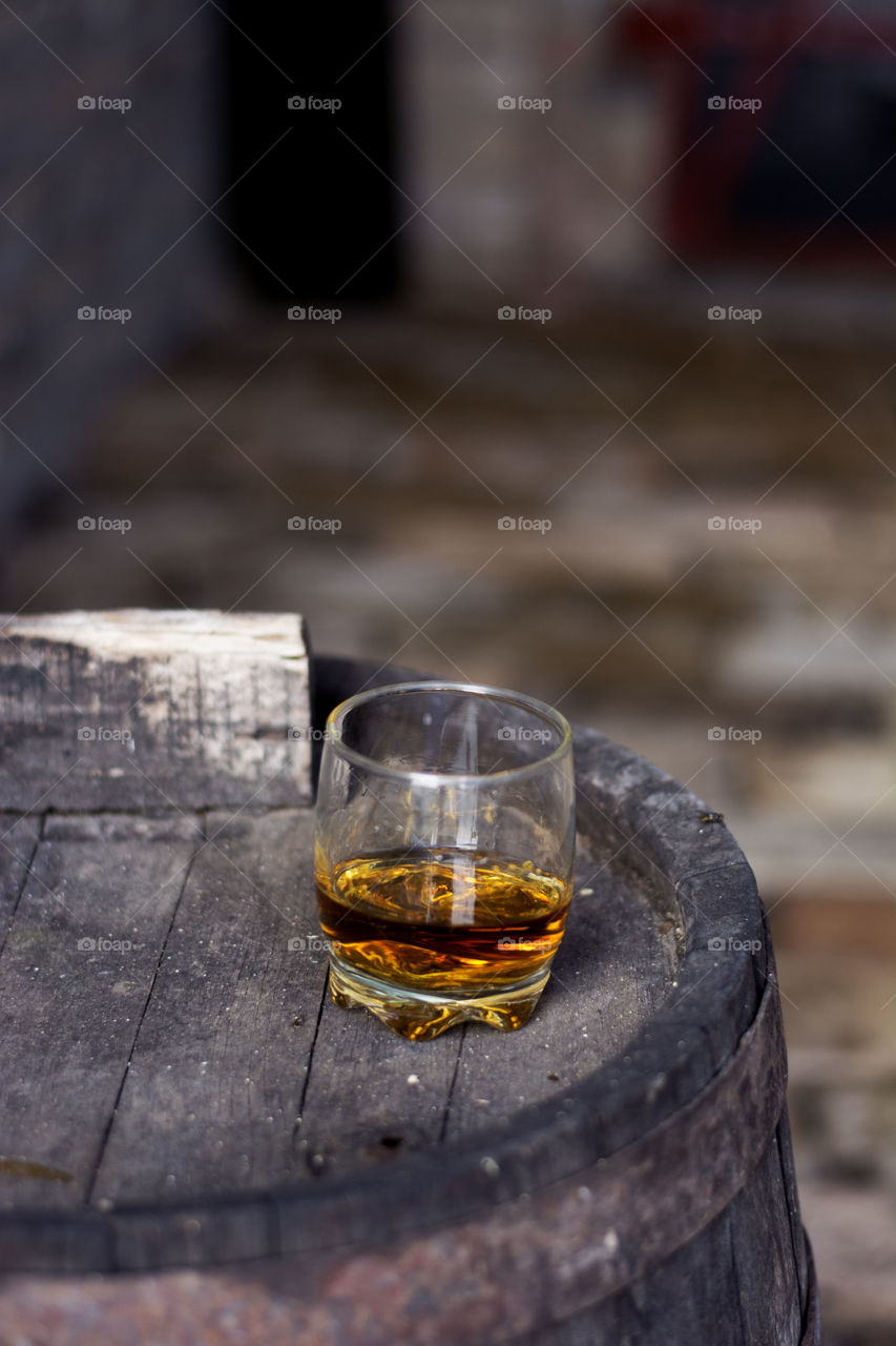 glass of whiskey on barrel. glass of whiskey neat without ice on wooden barrel