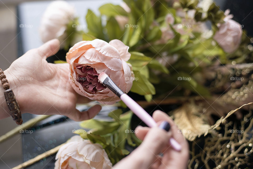 Women painting fake rose