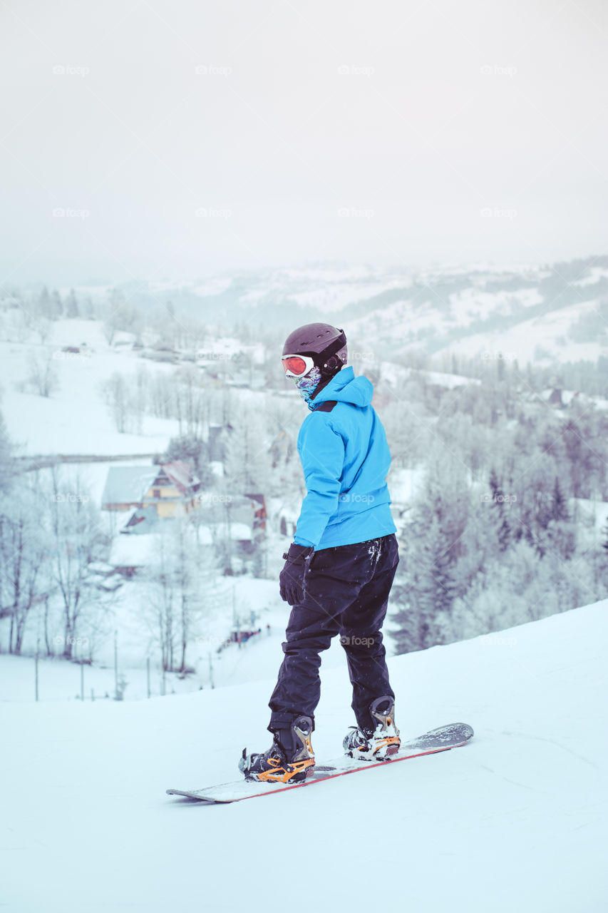 Boy riding a snowboard down the slope