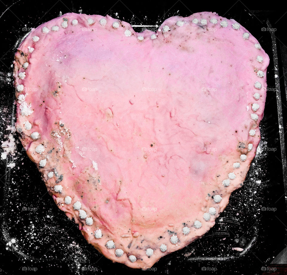 A pink heart cake with icing
