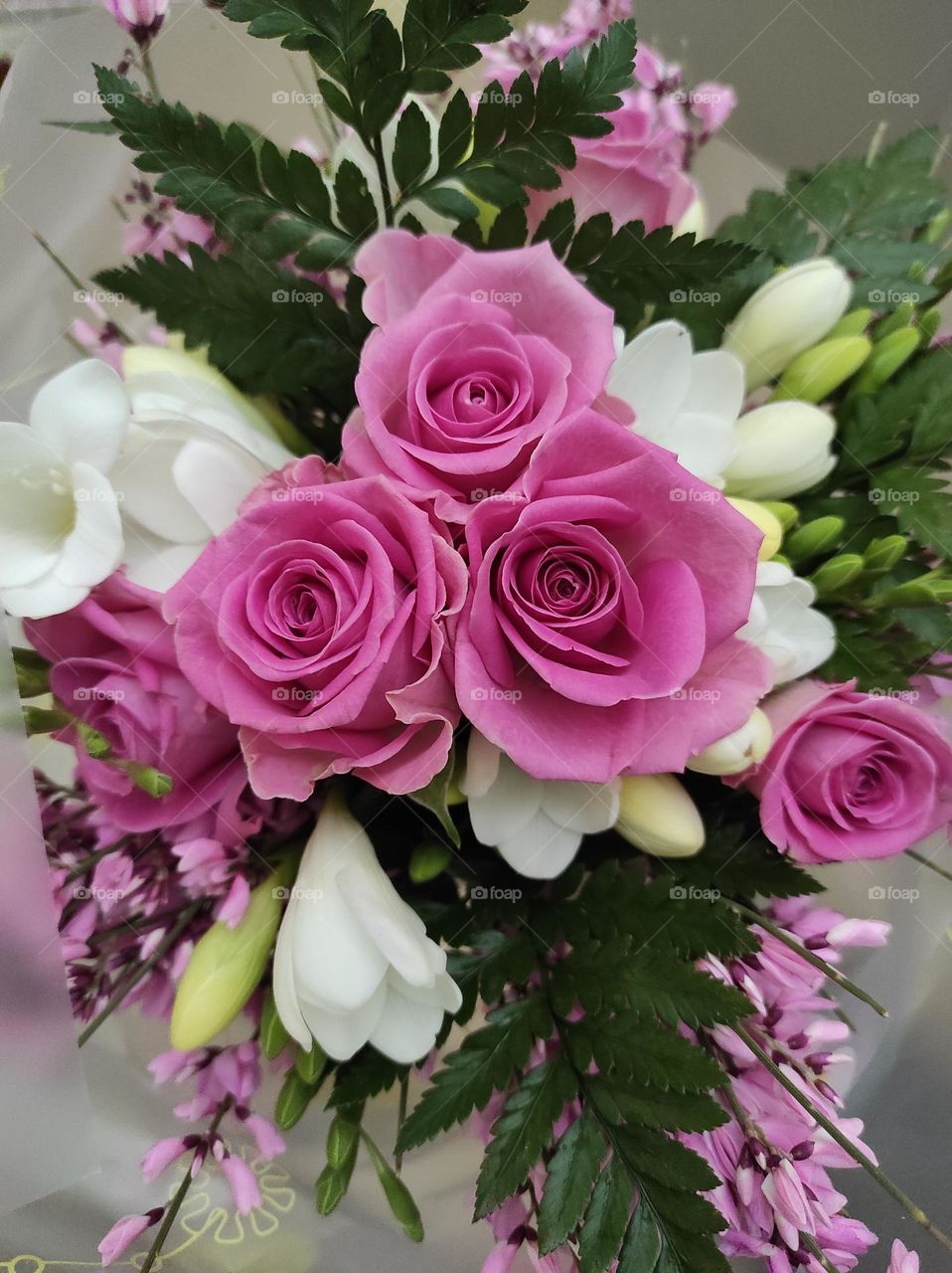 bunch of flowers with roses and white freesias