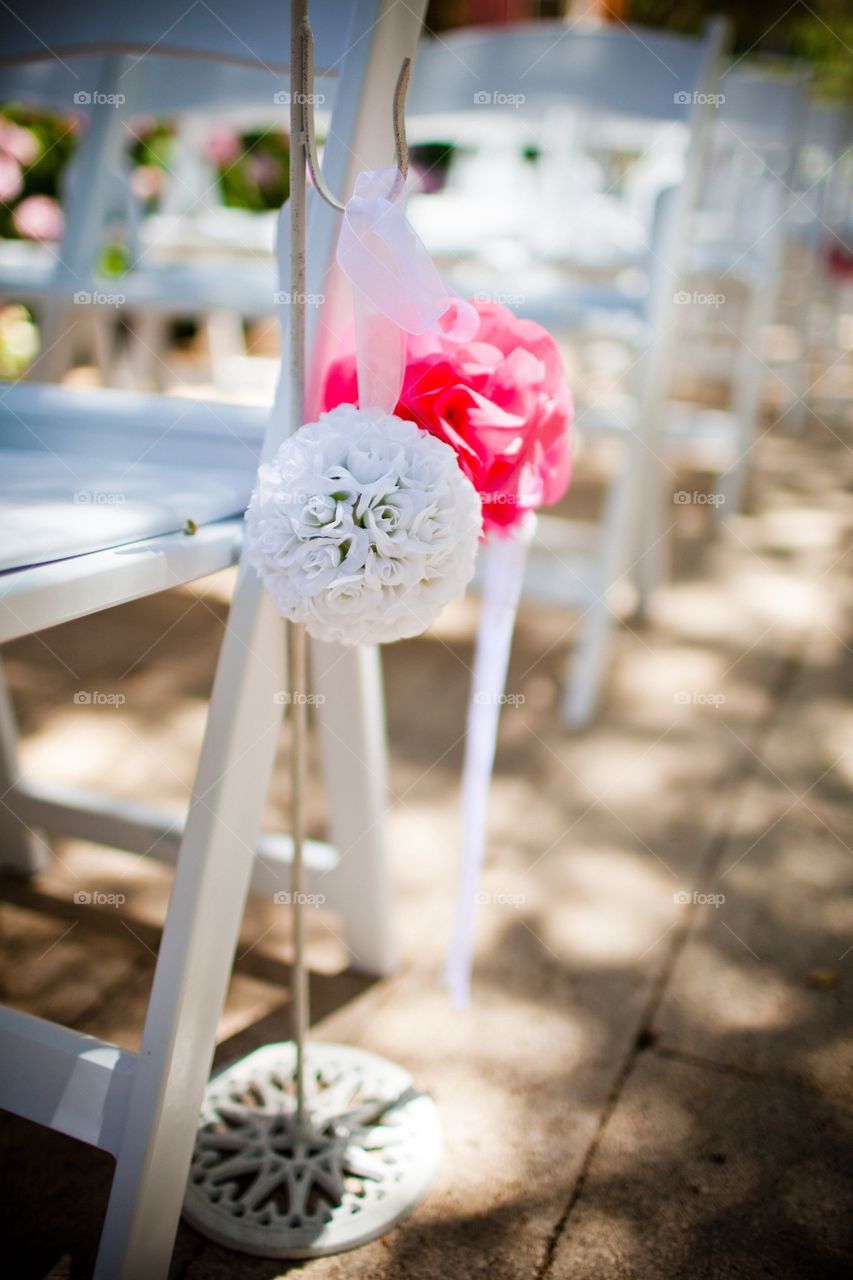 Flower decor on wedding ceremony chairs outdoors 