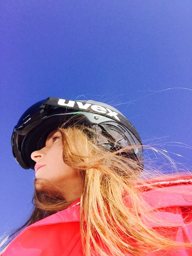 Portrait of woman wearing Uvex ski helmet and Uvex ski glasses with blue sky above
