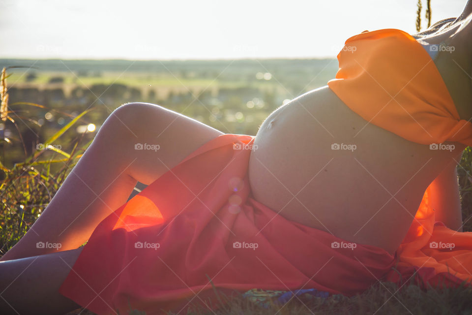 Pregnant woman relaxing in field