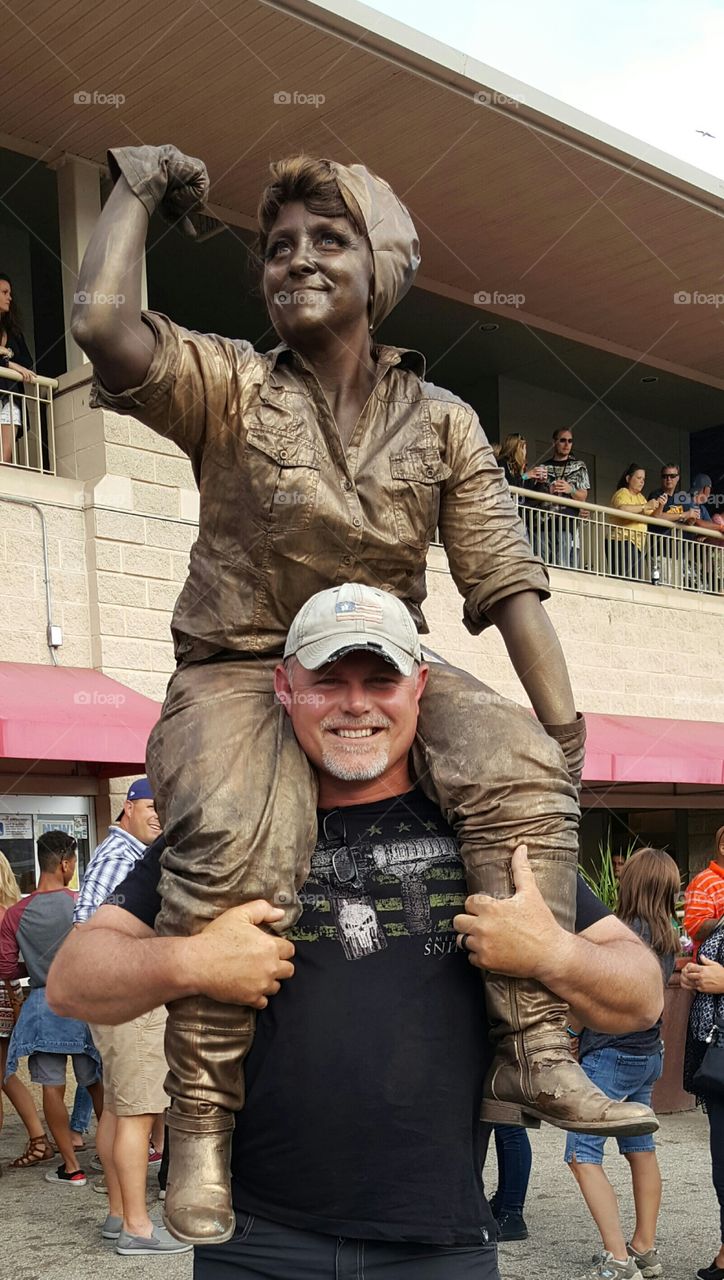 Man carrying a painted person on his shoulder