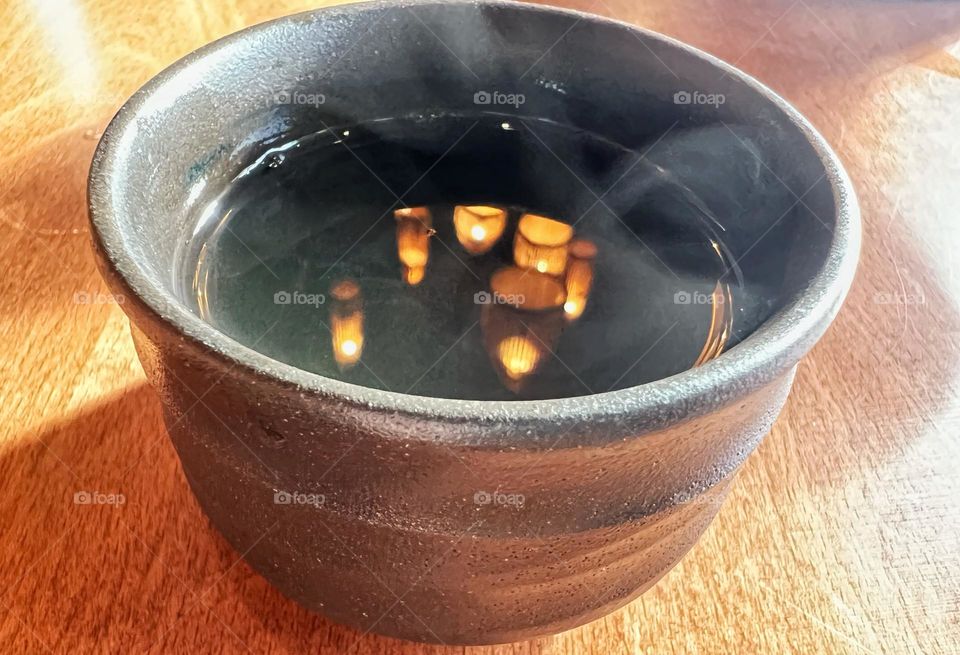 Steaming tea with reflection of lights