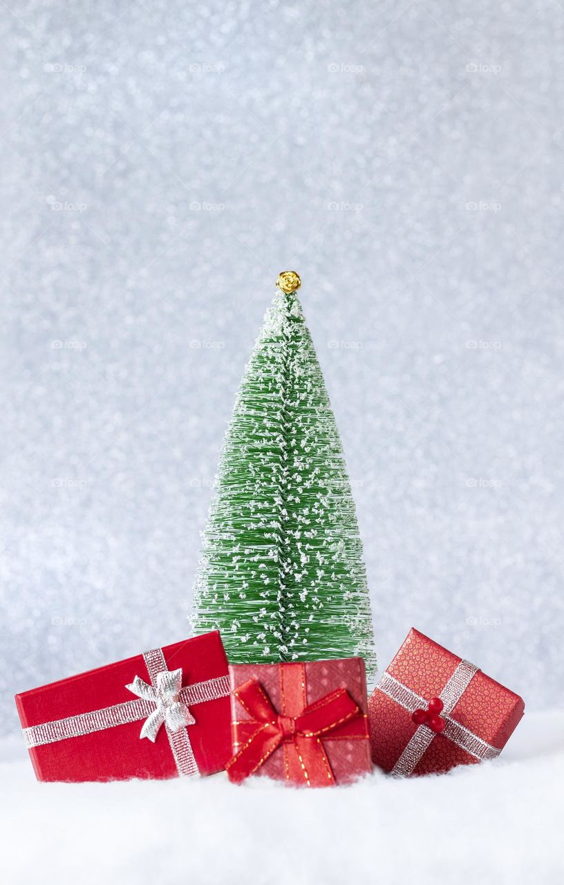 Christmas tree with presents against a glittery backdrop 