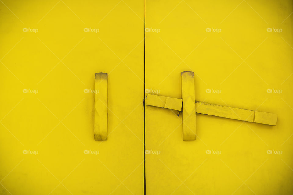 Yellow wooden latch. Yellow wooden latch on a yellow building
