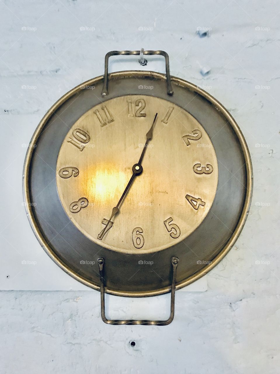 A clock made of an old pan on the wall 