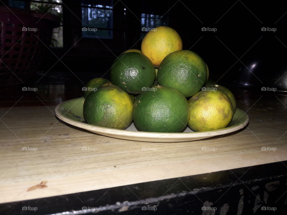 Green and yeallow colour leamon on a plate