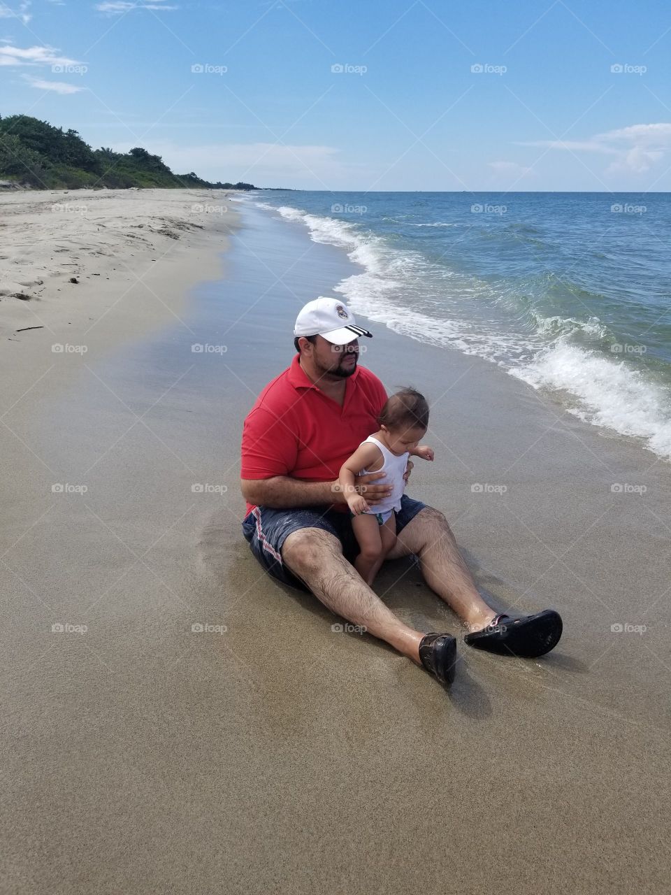 En las playas en un día de verano caluroso con mi pequeño hijo. su primera vez en el mar.