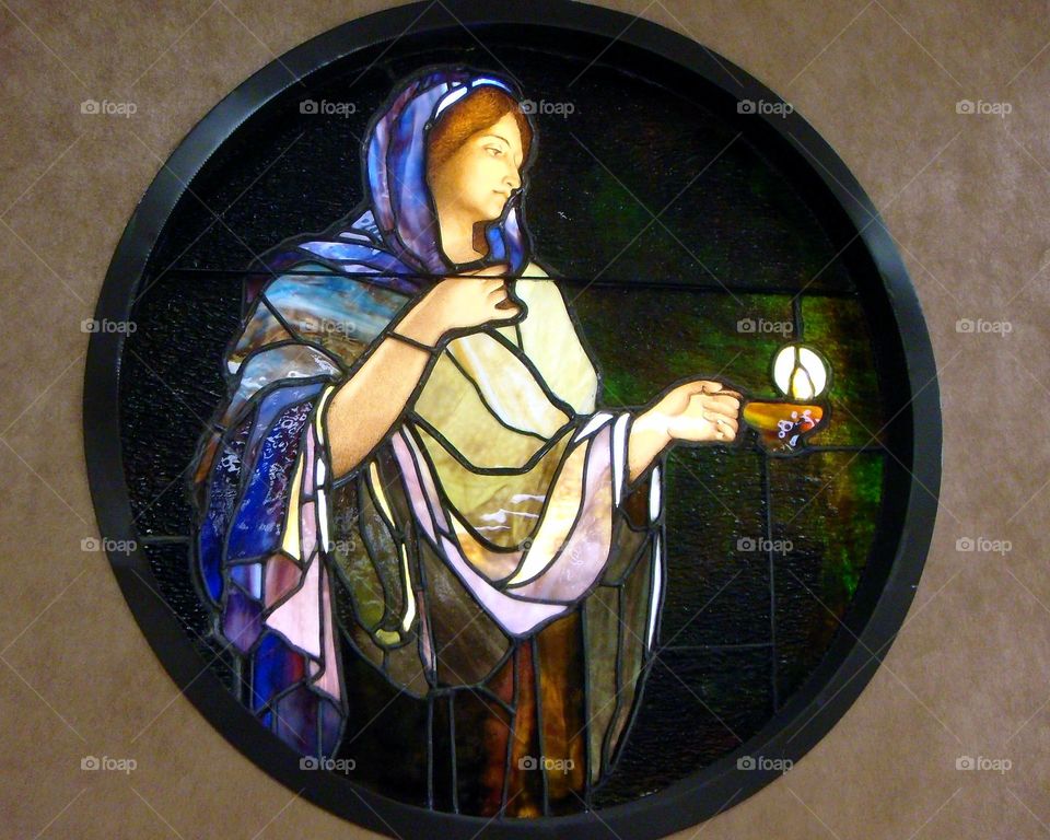 Religious stained glass in chapel, handmade. Round shape, colorful.