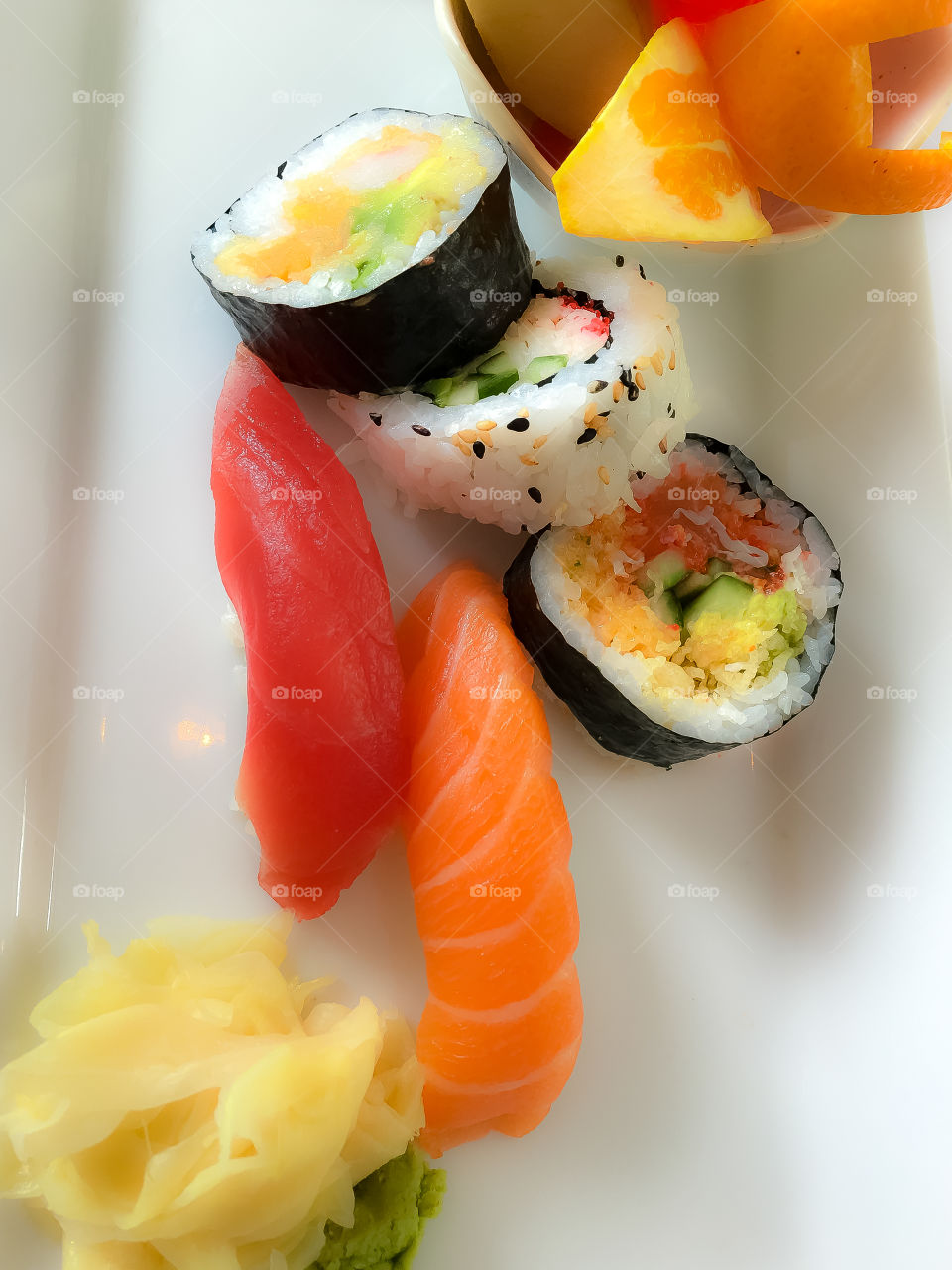 Japanese plate of sushi with salmon sashimi, maki, California roll