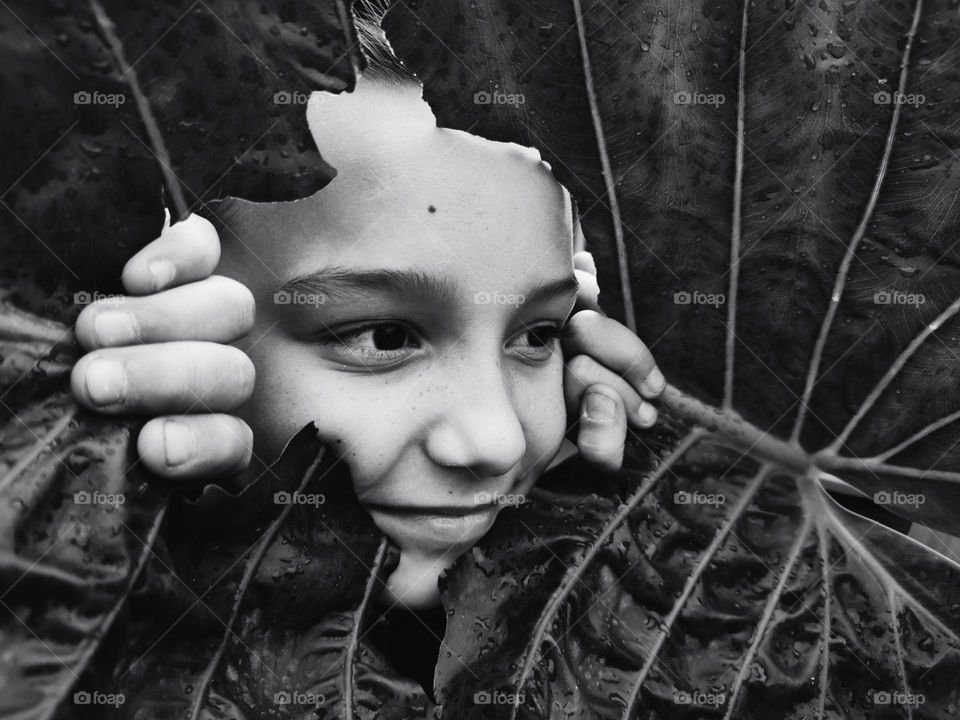 Portrait of girl, through ripped leaf