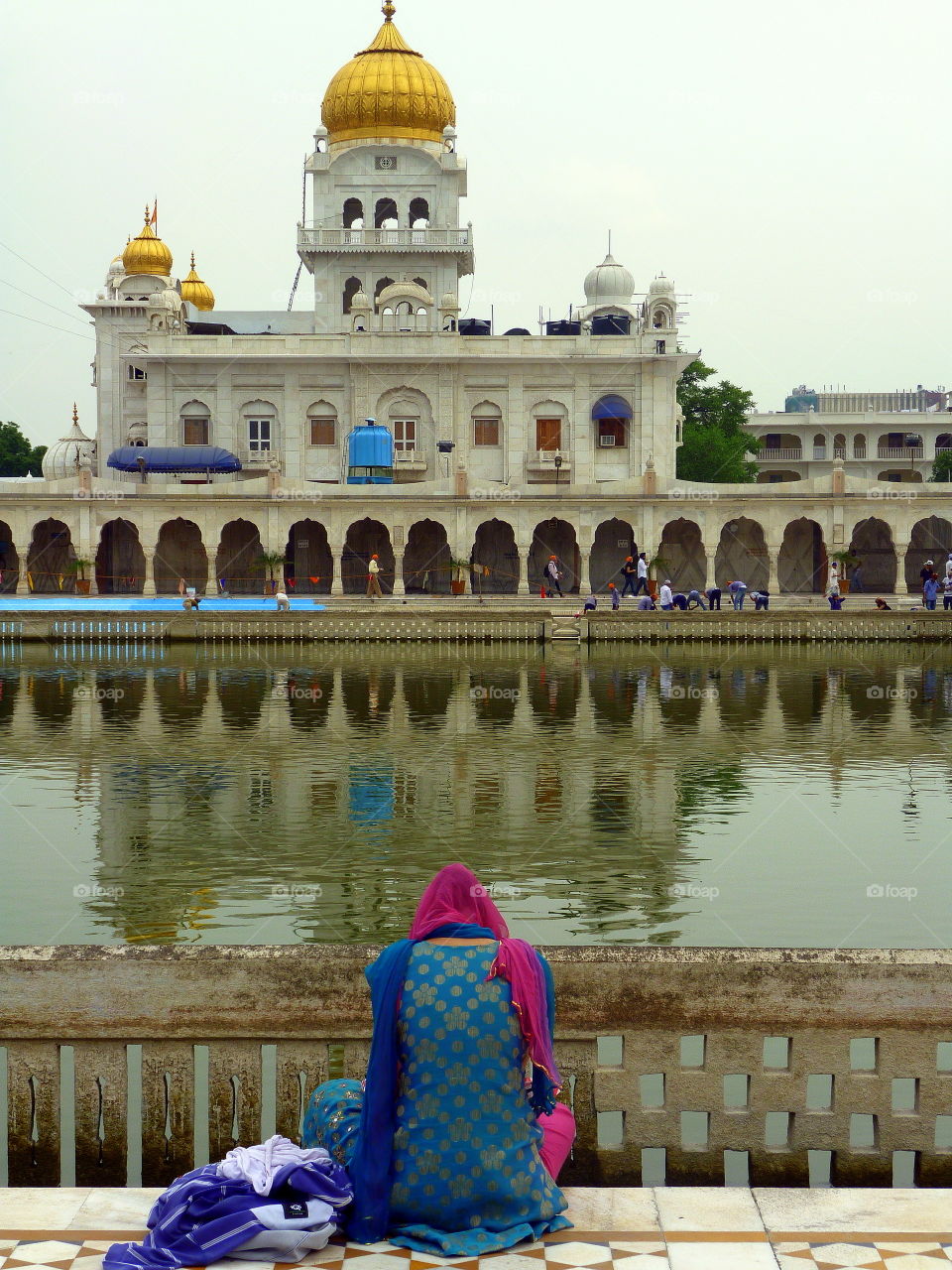 sitting near the water in front of the indian temple