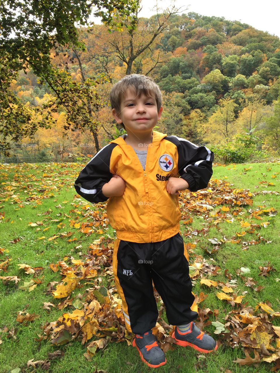 Fall scenery . Adorable toddler ready for game day