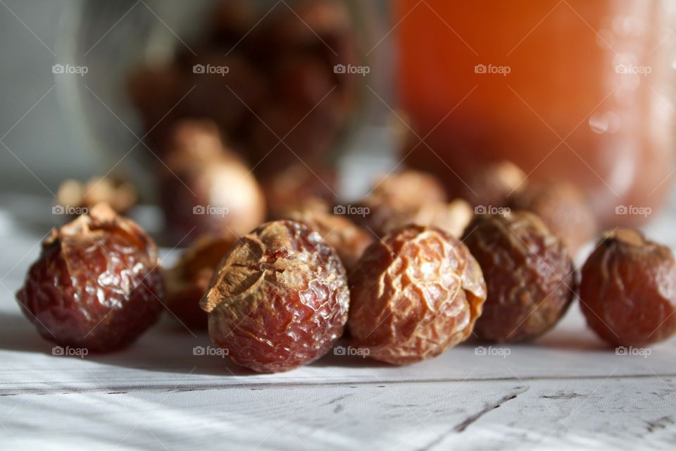 Closeup of soap nuts or soap berries on white wooden surface in natural light