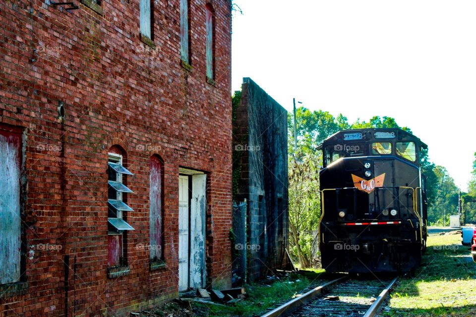 Old abandoned building next to a train