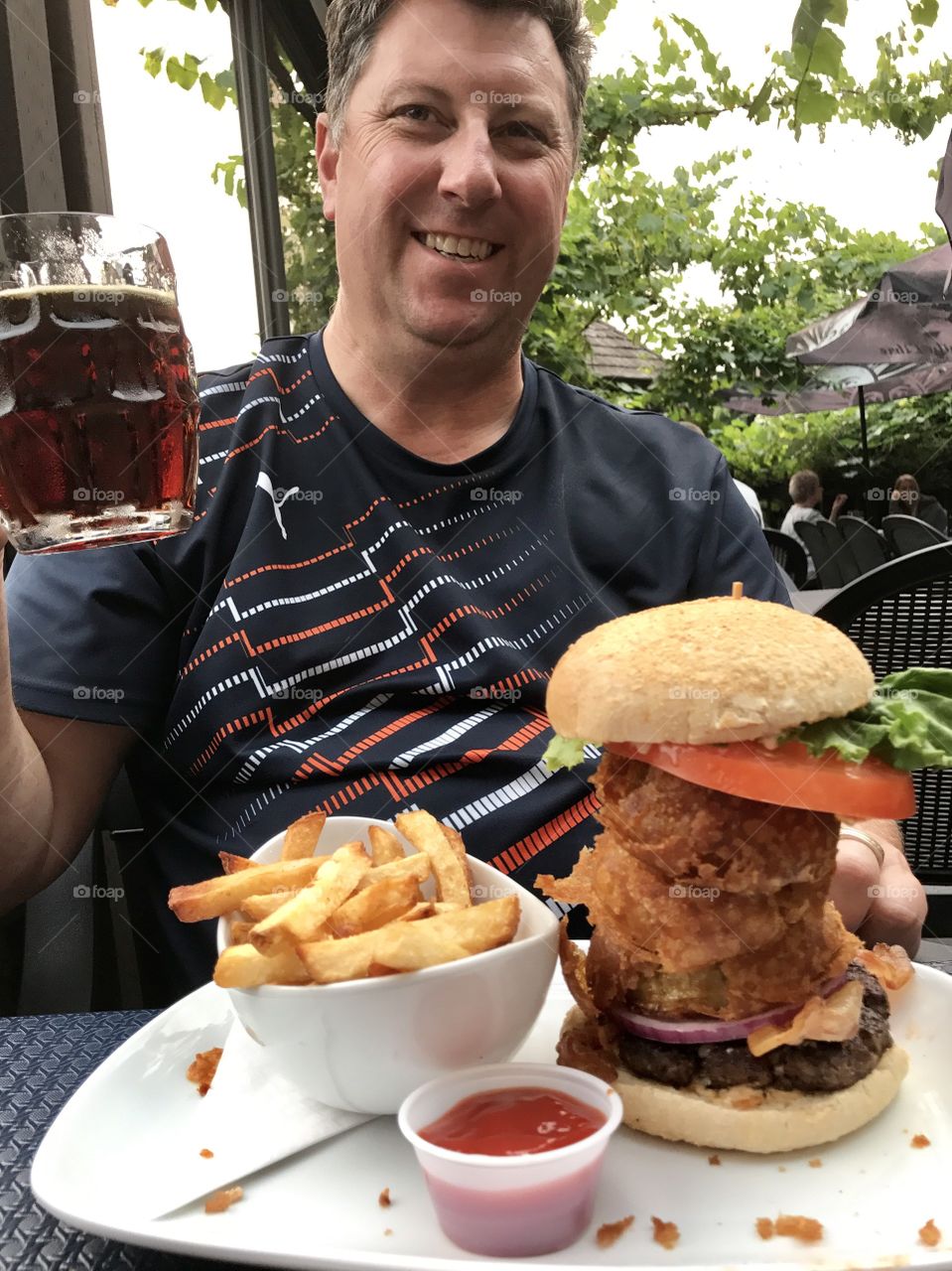 Towering burger, French fries and beer for lunch.