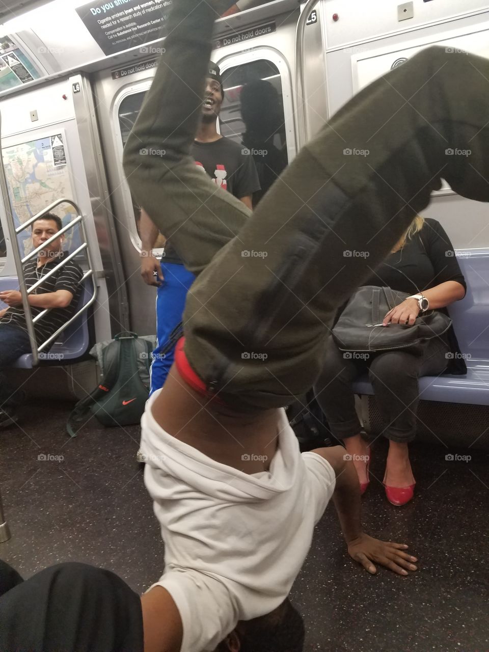 Man doing handstand in train