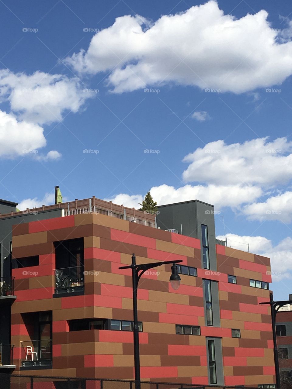 Colorful red and brown building with bright blue sky and clouds 