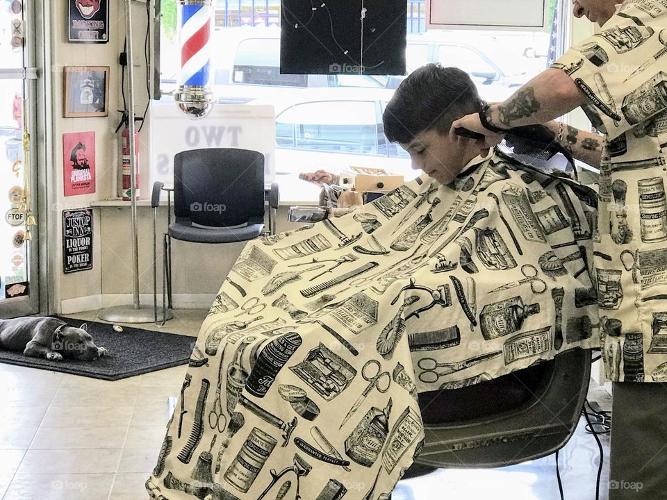 Boy getting hair cut in Barber shop 