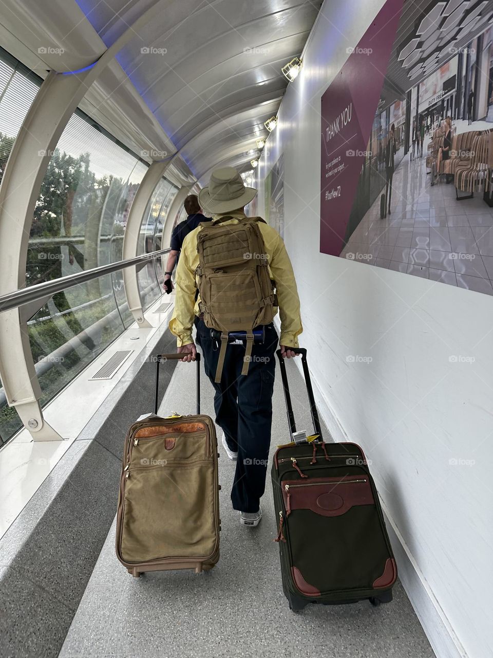 Father being the family pack mule through Manchester airport on vacation in England summer holiday luggage travel