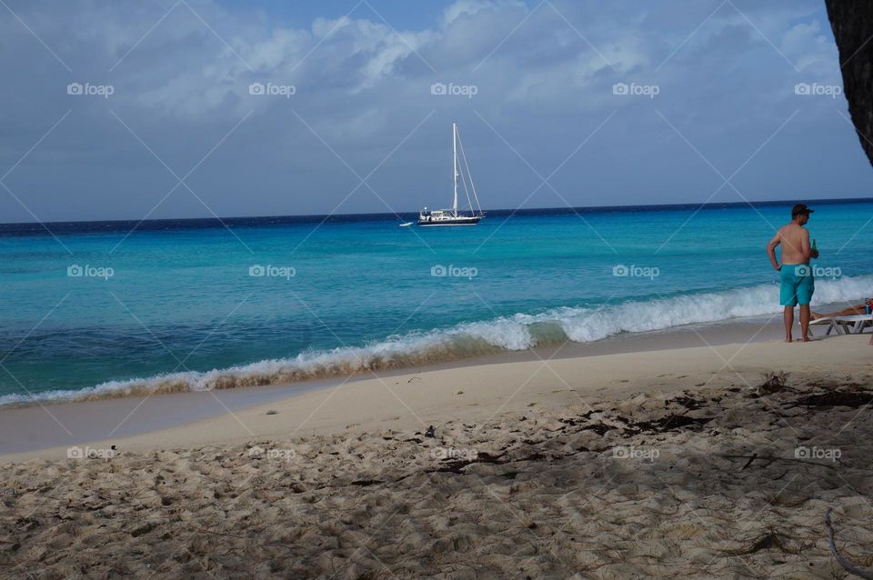 Vibrant ocean with beach and sale boat views