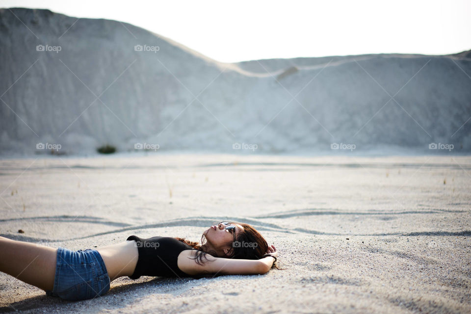 Teenage girl lying on sand