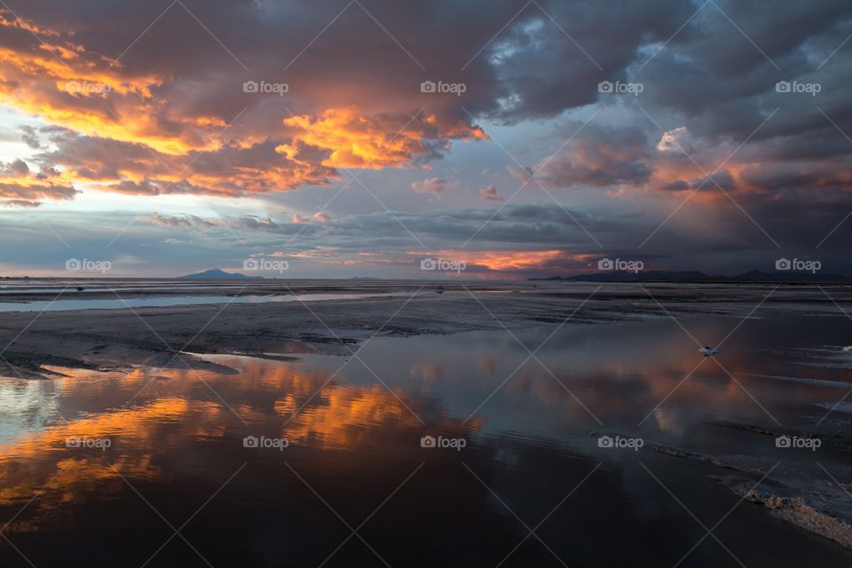 Sunset in Yuni salt flat. Dramatic sunset in Yuni salt flat in Bolivia. Reflection of colorful sky from water
