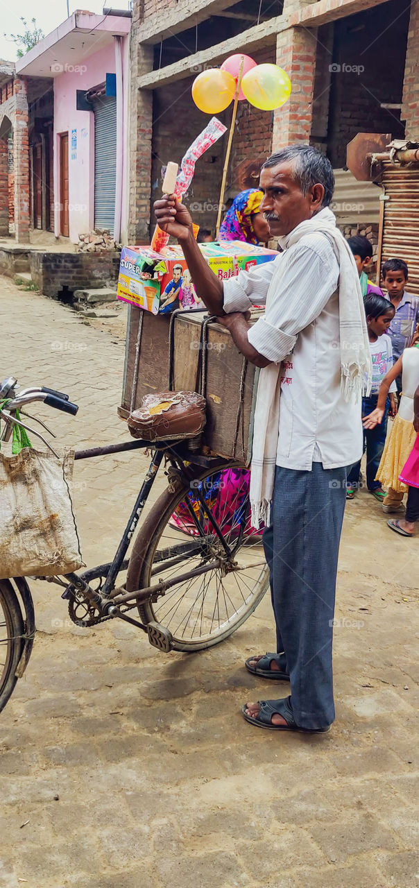 A Man selling ice-cream on cycle in rural to feed his family