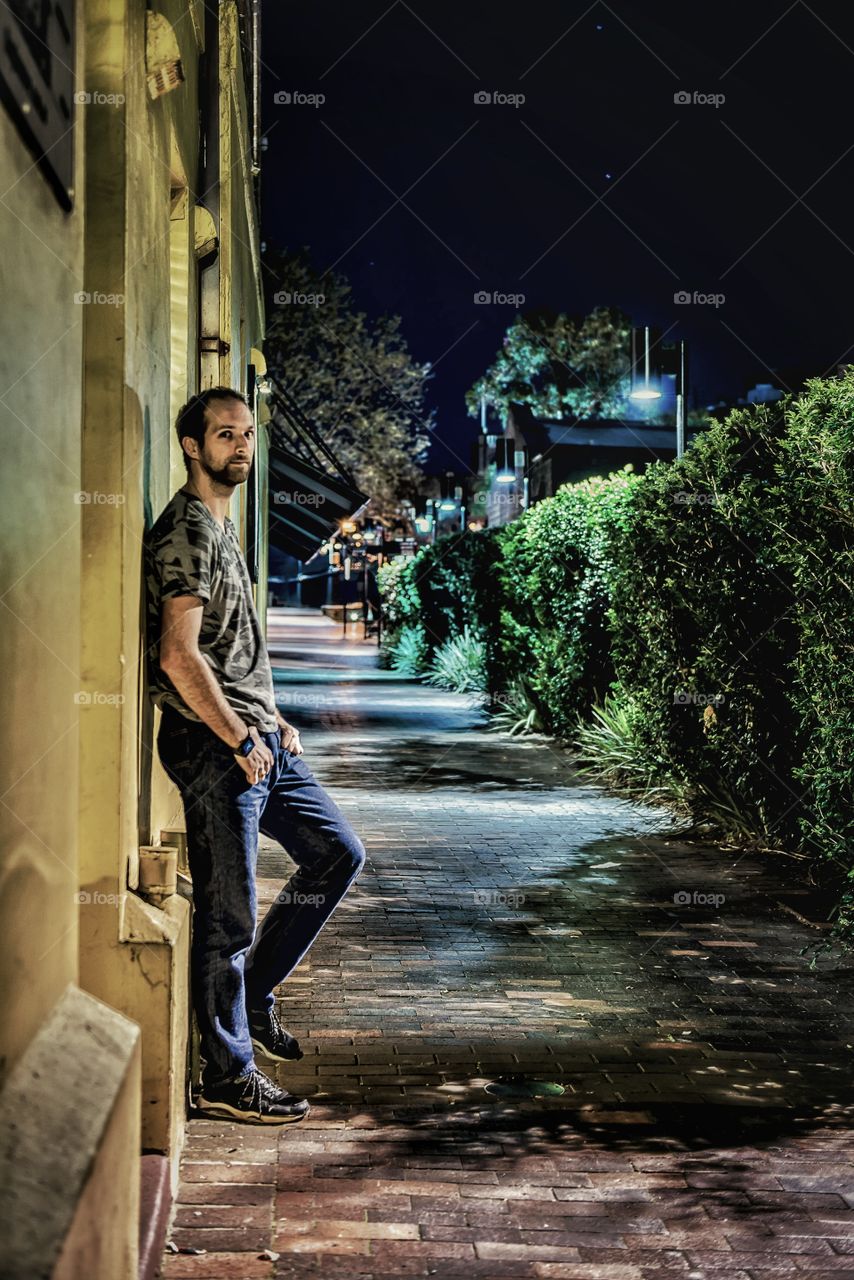 Young man leaning on building