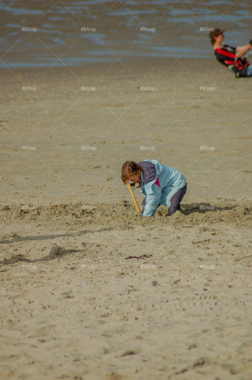 Girl Playing At The Beach With A Shovel