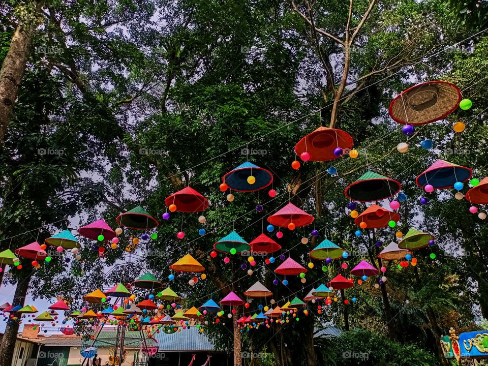 In preparation for the festival, umbrellas are hung on a rope tied between the poles to enliven the event