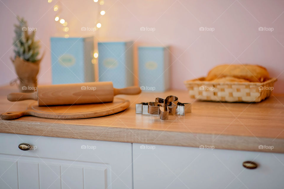 Festive winter cozy kitchen interior with garlands, decorations and gifts.  Christmas dinner at the decorated table.