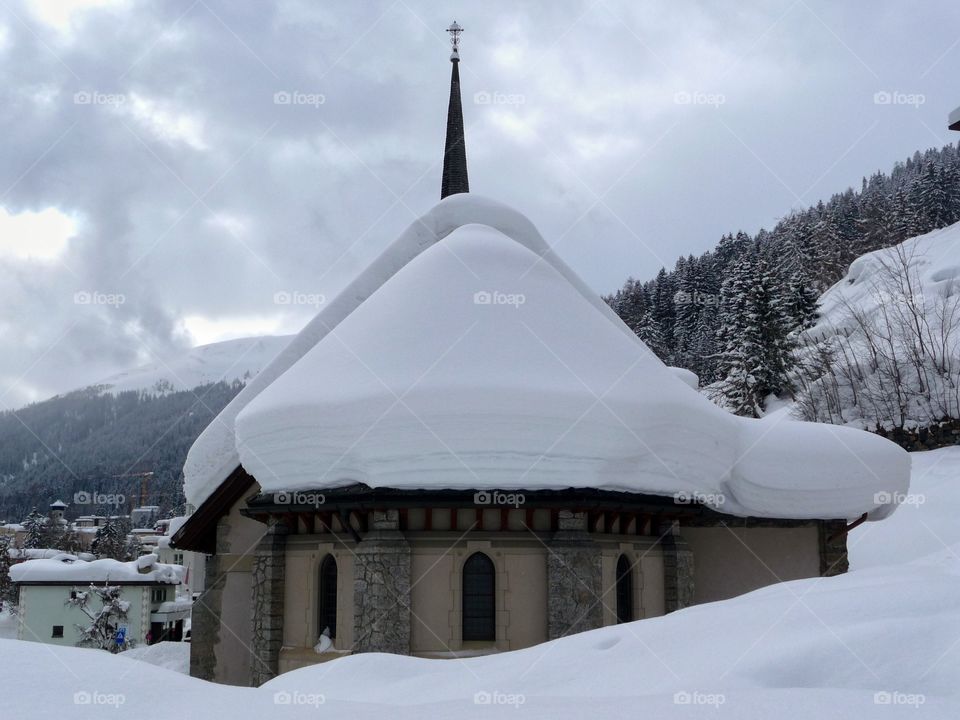 Chapel loaded with snow seen during a winter walk