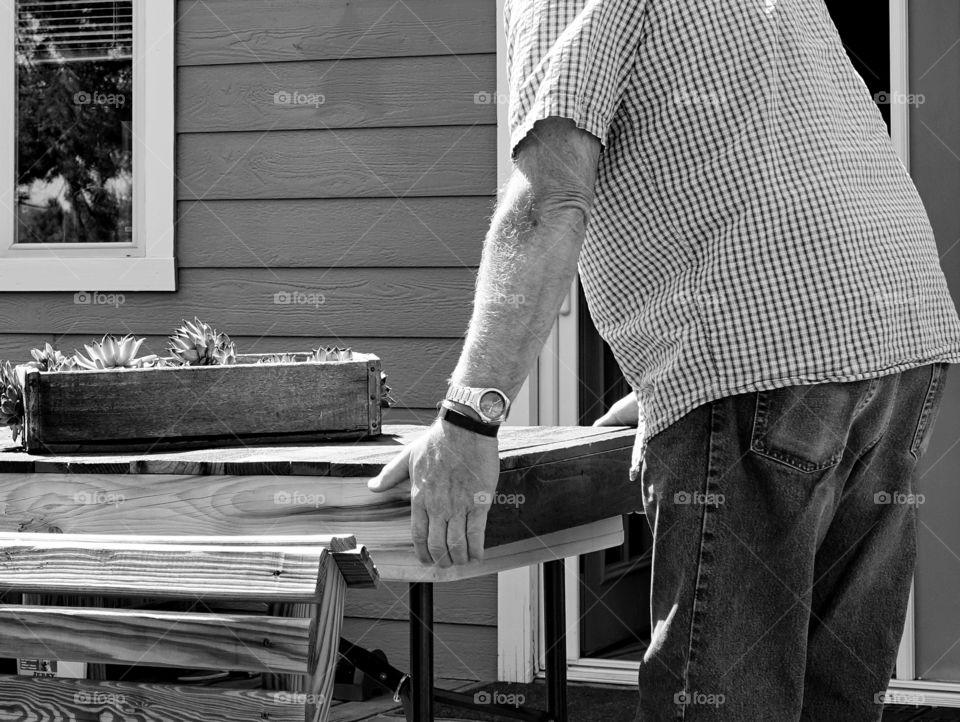 A man helps move a table to a better location. 