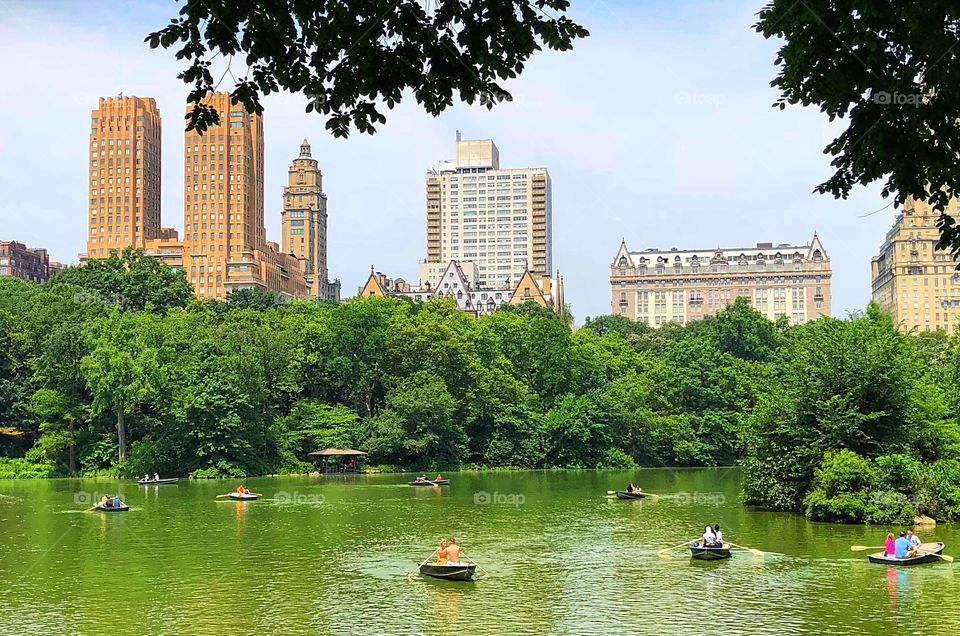 A view of Central Park on a beautiful summer day! A slew of boats come out on the lake to enjoy the wonderful weather! 
