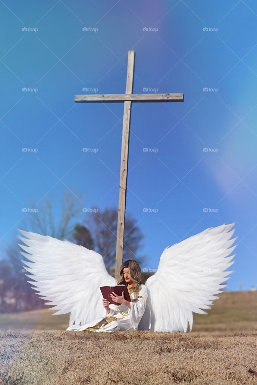 Angel reading a Bible in front of a cross! 