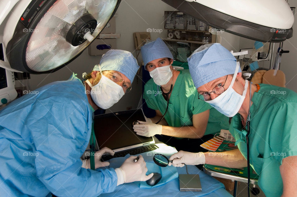 Three-man operate on a computer in the emergency room at a hospital