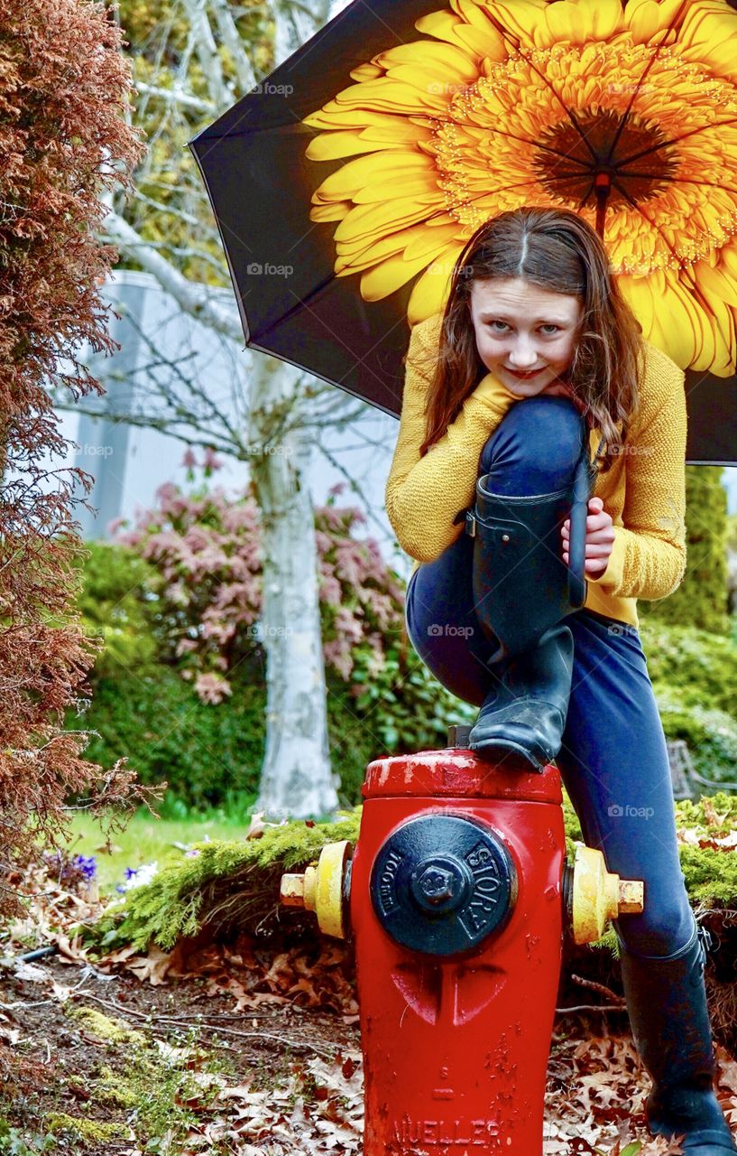 Girl hides from impending rain storm as the first drops fall 