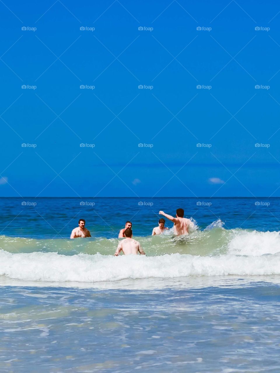 friends swimming and playing on the waves of the Brazilian Ocean.
Blue water and beautiful beach.