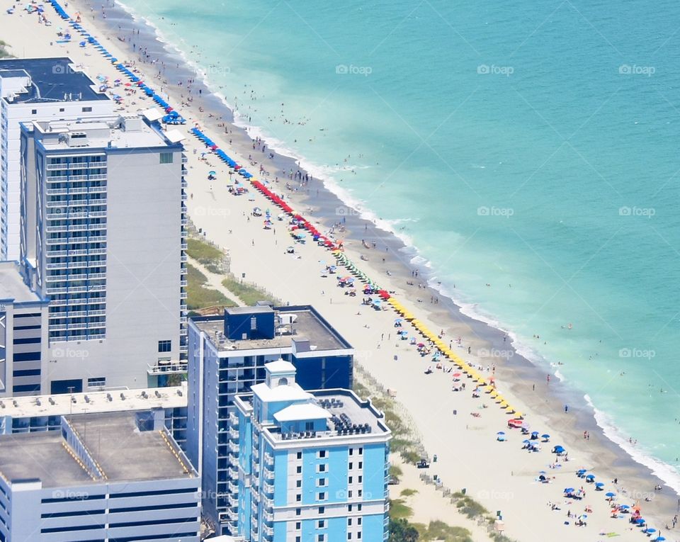 Landscape of Myrtle Beach, SC, beautiful blue ocean and white sand, beach umbrellas lines all the way up the beach