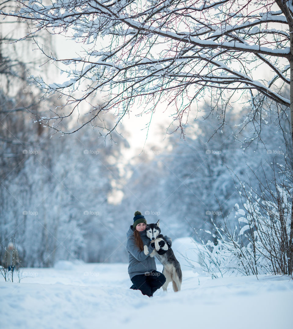 Walking with husky in winter park at sunny cold day